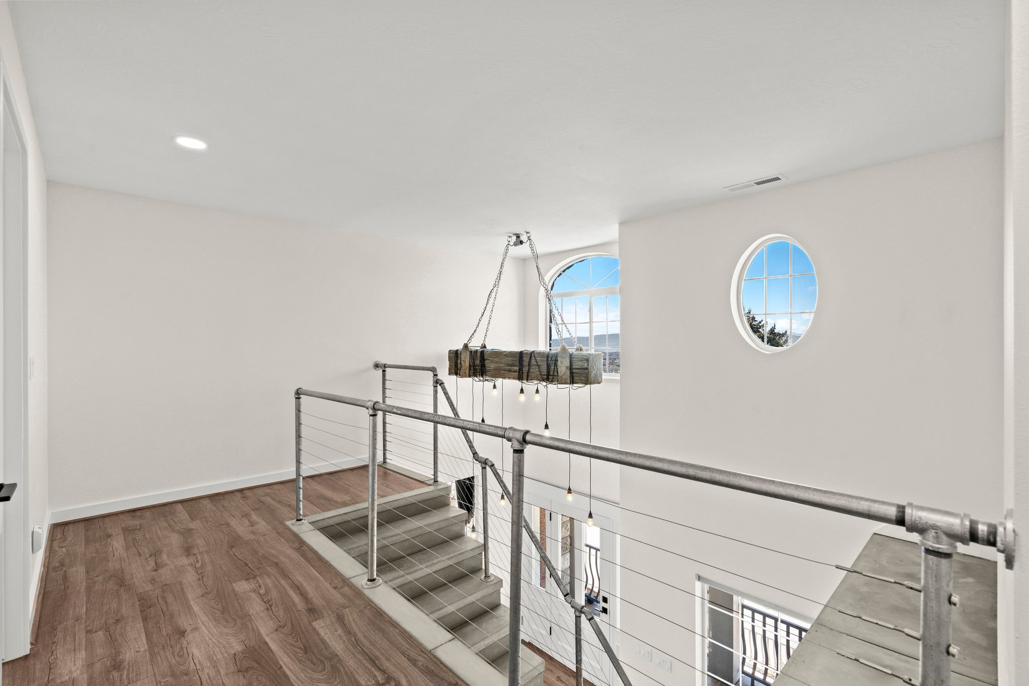 Hall featuring dark wood-style flooring, recessed lighting, and an upstairs landing