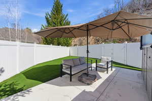 Fenced backyard with a gate, a patio area, and outdoor seating