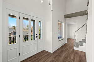 Foyer entrance featuring dark wood-style flooring and a high ceiling