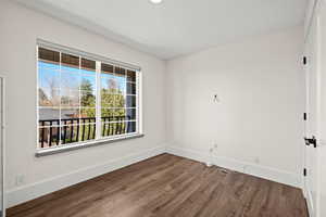 Unfurnished room featuring baseboards and dark wood finished floors