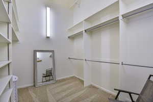 Walk in closet with light carpet