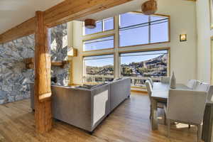 Living room featuring a fireplace, a high ceiling, light wood finished floors, and a mountain view