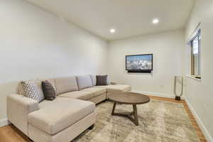 Living area with light wood-style flooring and recessed lighting