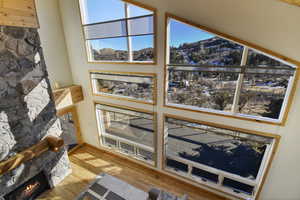 Detailed view of a mountain backdrop, a stone fireplace, and wood finished floors