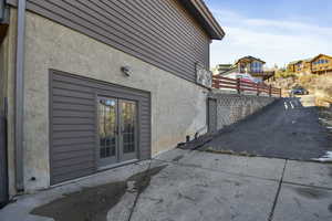 View of side of property with stucco siding, french doors, and a patio