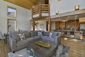 Living room featuring light wood-style flooring, a high wooden ceiling, and recessed lighting