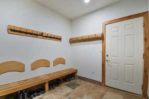 Mudroom with stone finish flooring and recessed lighting