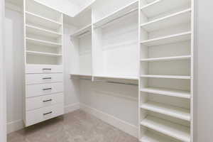 Walk in closet with light carpet