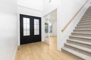 Entryway with french doors, light wood-style flooring, and plenty of natural light
