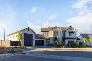 View of front of home featuring stucco siding, decorative driveway, an attached garage, and a chimney