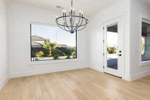 Unfurnished dining area featuring suspended lighting and light wood finished floors