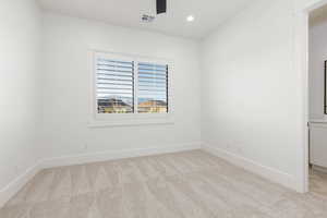 Spare room featuring recessed lighting, light carpet, and ceiling fan