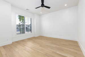 Spare room featuring light wood-style floors, ceiling fan, and recessed lighting