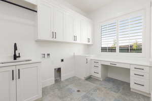 Laundry room with washer hookup, electric dryer hookup, light stone finish flooring, cabinet space, and an office area
