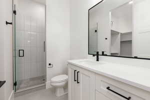Full bath with vanity, a stall shower, light tile patterned flooring, and a walk in closet