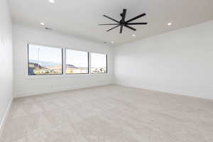 Unfurnished room featuring a mountain view, a ceiling fan, light carpet, and recessed lighting