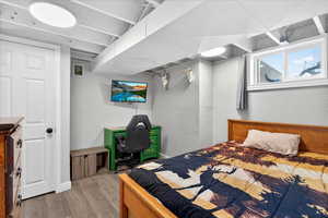 Bedroom with wood finished floors and a textured wall