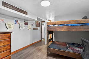 Bedroom with light wood-type flooring and a textured ceiling
