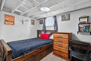 Bedroom featuring a textured wall and light wood-style flooring