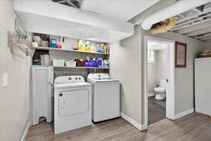 Laundry area with light wood finished floors and independent washer and dryer