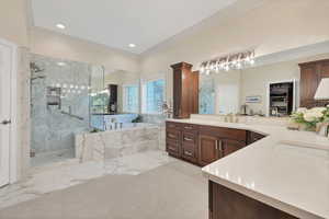 Bathroom featuring ornamental molding, a marble finish shower, a garden tub, vanity, and recessed lighting