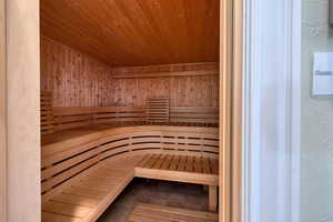 Relaxing sauna / steam room featuring wood ceiling and wood walls