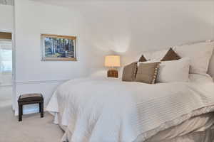 Bedroom with carpet flooring and vaulted ceiling