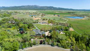 Aerial view of property and surrounding area featuring rural landscape and a water and mountain view