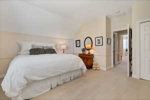 Bedroom featuring carpet floors and vaulted ceiling