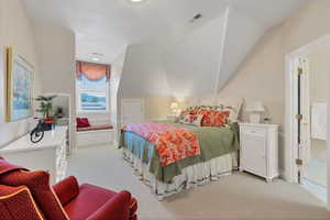 Bedroom featuring light carpet and lofted ceiling