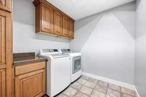 Laundry area with cabinet space and washer and clothes dryer