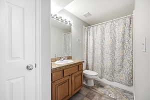 Full bathroom with vanity, a textured ceiling, and shower / bath combo with shower curtain