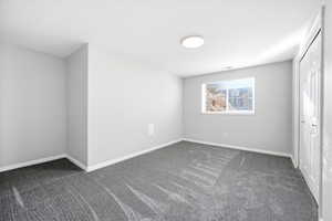 Unfurnished bedroom with dark colored carpet and a closet