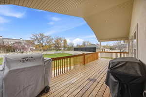 Wooden deck with grilling area, a fenced backyard, and a residential view