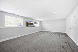 Carpeted empty room with baseboards and recessed lighting