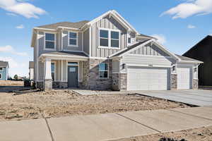 Craftsman-style house with an attached garage, concrete driveway, board and batten siding, a porch, and stone siding