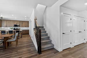 Staircase with recessed lighting and wood finished floors