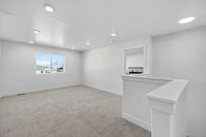 Spare room featuring light colored carpet and recessed lighting