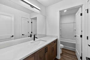 Bathroom featuring vanity, dark wood-type flooring, and tub / shower combination