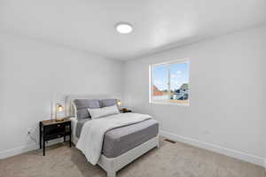 Bedroom with baseboards and light colored carpet