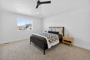 Bedroom with light colored carpet, a ceiling fan, recessed lighting, and a mountain view