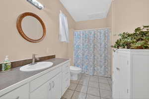Bathroom with vanity, curtained shower, and light tile patterned floors