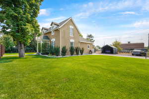 View of home's exterior with a yard, stucco siding, and a carport