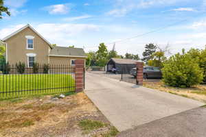 View of front of house with stucco siding, a fenced front yard, a gate, and concrete driveway