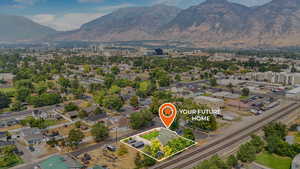 Aerial view of property and surrounding area featuring property parcel outlined and a mountainous background
