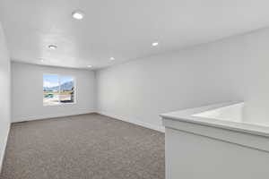 Carpeted empty room with recessed lighting, a mountain view, and a textured ceiling