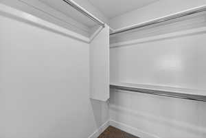 Walk in closet with dark colored carpet