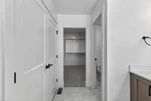 Bathroom with a walk in closet, a textured ceiling, and vanity
