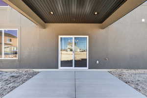 Doorway to property with stucco siding and a patio area