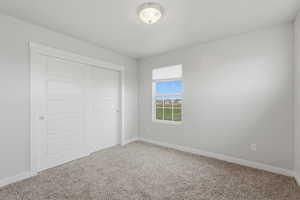 Unfurnished bedroom with a closet and light carpet